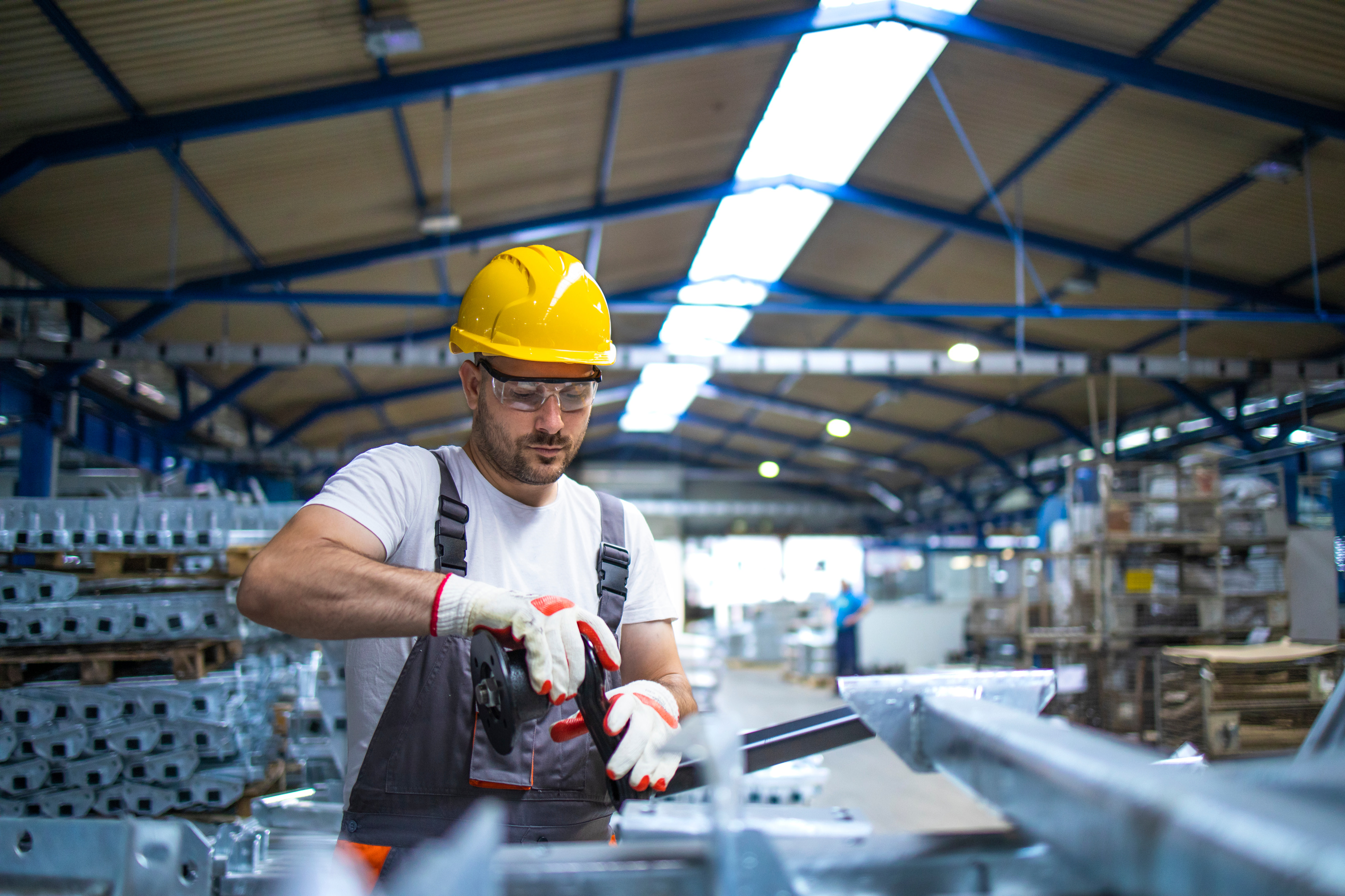 Factory worker assembling meal parts for automobile industry.